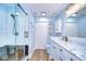 Bathroom with a glass shower, dual vanities, marble counters, and modern fixtures at 9304 Lake Chase Island Way, Tampa, FL 33626