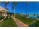 Exterior view of condo buildings and a lake. Path with street lamp in the foreground at 9304 Lake Chase Island Way, Tampa, FL 33626