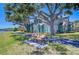 Waterfront home with scenic walkway, mature trees, and park benches along the pathway at 9304 Lake Chase Island Way, Tampa, FL 33626
