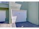 Garage access featuring white door with unit number, adjacent to shared driveway at 9304 Lake Chase Island Way, Tampa, FL 33626