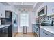 Contemporary kitchen features stainless steel appliances, gray cabinetry, and a tile backsplash at 9304 Lake Chase Island Way, Tampa, FL 33626