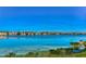 A wide lake reflects colorful townhouses under a clear blue sky in a serene setting at 9304 Lake Chase Island Way, Tampa, FL 33626