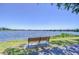 Picturesque lake view with a bench by the water, offering a peaceful and relaxing setting at 9304 Lake Chase Island Way, Tampa, FL 33626