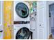This laundry area contains a stackable washer and dryer with shelving for storage at 9304 Lake Chase Island Way, Tampa, FL 33626