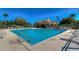 A swimming pool with handrails, lounge chairs, a gazebo, and various trees and shrubbery at 9304 Lake Chase Island Way, Tampa, FL 33626