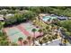 Aerial view showcases community tennis courts, pool, playground, surrounded by palm trees and lush landscaping at 9628 Charlesberg Dr, Tampa, FL 33635