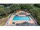 Aerial view of a community pool and playground surrounded by lush trees, ideal for Gathering fun and relaxation at 9628 Charlesberg Dr, Tampa, FL 33635