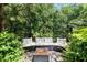 Secluded backyard retreat with plush seating, surrounded by verdant landscaping and ambient tiki torches at 9628 Charlesberg Dr, Tampa, FL 33635