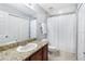 Cozy bathroom with a granite countertop, a framed mirror, and a shower with a curtain at 9628 Charlesberg Dr, Tampa, FL 33635