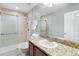 Bathroom with a granite countertop, a framed mirror, and a glass-enclosed tiled shower at 9628 Charlesberg Dr, Tampa, FL 33635
