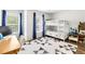 Bright bedroom featuring a white bunk bed, geometric rug, and light-filled windows with vibrant blue curtains at 9628 Charlesberg Dr, Tampa, FL 33635