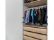 Spacious closet with an array of colorful clothing hanging above light wood drawers, providing ample storage at 9628 Charlesberg Dr, Tampa, FL 33635