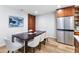 Modern dining area with stainless steel fridge and seating, bathed in natural light at 9628 Charlesberg Dr, Tampa, FL 33635