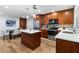 Open kitchen with wood cabinets, island, stainless steel appliances, tile backsplash, and an adjacent dining area at 9628 Charlesberg Dr, Tampa, FL 33635