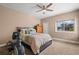 Comfortable bedroom with ceiling fan, large window, and neutral paint at 9727 Tiffany Oaks Ln, Tampa, FL 33612