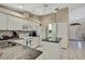 Well-lit kitchen featuring white cabinetry, granite countertops and a breakfast bar for convenience at 9730 Reynosa Dr, New Port Richey, FL 34655
