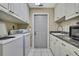Well-equipped laundry room with modern appliances and ample cabinet space at 9730 Reynosa Dr, New Port Richey, FL 34655