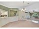 Inviting living area with neutral decor, chandelier, and views to the kitchen and main entryway at 9730 Reynosa Dr, New Port Richey, FL 34655