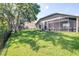 Backyard features a screened-in patio, lush lawn and fence at 10016 Oxford Chapel Dr, Tampa, FL 33647
