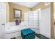Close-up of a soaking tub with custom tile, glass block shower, and blue ottoman in the home's bathroom at 10016 Oxford Chapel Dr, Tampa, FL 33647