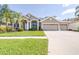 Charming one-story home with a well-manicured lawn, lush landscaping, and a spacious two-car garage at 10016 Oxford Chapel Dr, Tampa, FL 33647