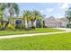Charming one-story home with a well-manicured lawn, lush landscaping, and a spacious two-car garage at 10016 Oxford Chapel Dr, Tampa, FL 33647