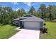 Beautifully landscaped home exterior showcasing a well-manicured lawn, attached garage, and vibrant curb appeal at 11470 Mahopac Rd, Weeki Wachee, FL 34614