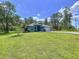 Single-story home with a manicured lawn and landscaping in a serene, wooded setting at 11470 Mahopac Rd, Weeki Wachee, FL 34614