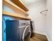 Laundry room with gray appliances and wooden shelves at 11470 Mahopac Rd, Weeki Wachee, FL 34614