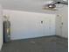 View of a spacious garage, including a water heater and two access doors at 11529 Misty Isle Ln, Riverview, FL 33579