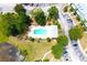 Aerial view of community pool with surrounding trees and parking areas at 11622 Declaration Dr, Tampa, FL 33635
