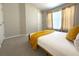 Bedroom with neutral walls, carpet, yellow throw blanket, and natural light from a window at 11622 Declaration Dr, Tampa, FL 33635