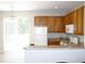 Bright kitchen featuring wood cabinets, white appliances, and a breakfast bar overlooking the adjacent dining area at 11622 Declaration Dr, Tampa, FL 33635