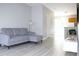 Inviting living room featuring a grey sofa with an ottoman, wood-look flooring, and a contemporary design at 11622 Declaration Dr, Tampa, FL 33635
