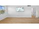 Bright living room with wood floors, white walls and trim, and large TV at 1225 58Th N St # 204A, St Petersburg, FL 33710