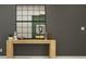 Modern entryway with decoratively appointed table and decorative mirror on gray wall at 12609 Aura Moonlight Ter, Parrish, FL 34219
