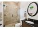 Elegant bathroom featuring tiled shower with glass enclosure, decorative mirror, and dark granite countertop vanity at 134 Chesapeake Ave, Tampa, FL 33606