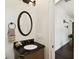 Stylish bathroom featuring a dark vanity with a carved front and an oval mirror with an elegant fixture at 134 Chesapeake Ave, Tampa, FL 33606