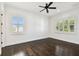 Bright bedroom with hardwood floors, white walls, ceiling fan and two windows with plantation shutters at 134 Chesapeake Ave, Tampa, FL 33606