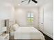 Calm bedroom featuring a tufted headboard bed, dark wood floors, and a bright window with white shutters at 134 Chesapeake Ave, Tampa, FL 33606