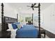 Bedroom featuring a dark wood four-poster bed, ceiling fan, and a desk with chair at 134 Chesapeake Ave, Tampa, FL 33606