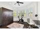 Bright exercise room with multiple windows, wood floors, ceiling fan, and dark armoire at 134 Chesapeake Ave, Tampa, FL 33606