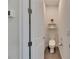 Clean bathroom featuring a modern toilet, floating shelves with fresh flowers, and tile flooring at 13539 Carryback Dr, Dade City, FL 33525