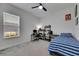 Inviting bedroom offers a comfortable sleeping area with a bed, ceiling fan and an organized workspace at 13539 Carryback Dr, Dade City, FL 33525