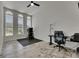 Bright room with three arched windows, ceiling fan, and grey wood-look tile at 13539 Carryback Dr, Dade City, FL 33525
