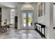Elegant foyer with double glass doors, pendant lighting, and tiled floors at 13539 Carryback Dr, Dade City, FL 33525