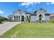 Stunning white home featuring lush landscaping and a paved driveway on a sunny day at 13539 Carryback Dr, Dade City, FL 33525