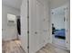Hallway with wood-look tile flooring, showcasing access to the bathroom and secondary bedroom at 13539 Carryback Dr, Dade City, FL 33525