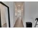 Bright hallway featuring neutral tile floors and white walls connecting various rooms in the home at 13539 Carryback Dr, Dade City, FL 33525