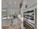 Bright, spacious kitchen with double ovens, white cabinets, and a view to the outdoor pool and dining area at 13539 Carryback Dr, Dade City, FL 33525